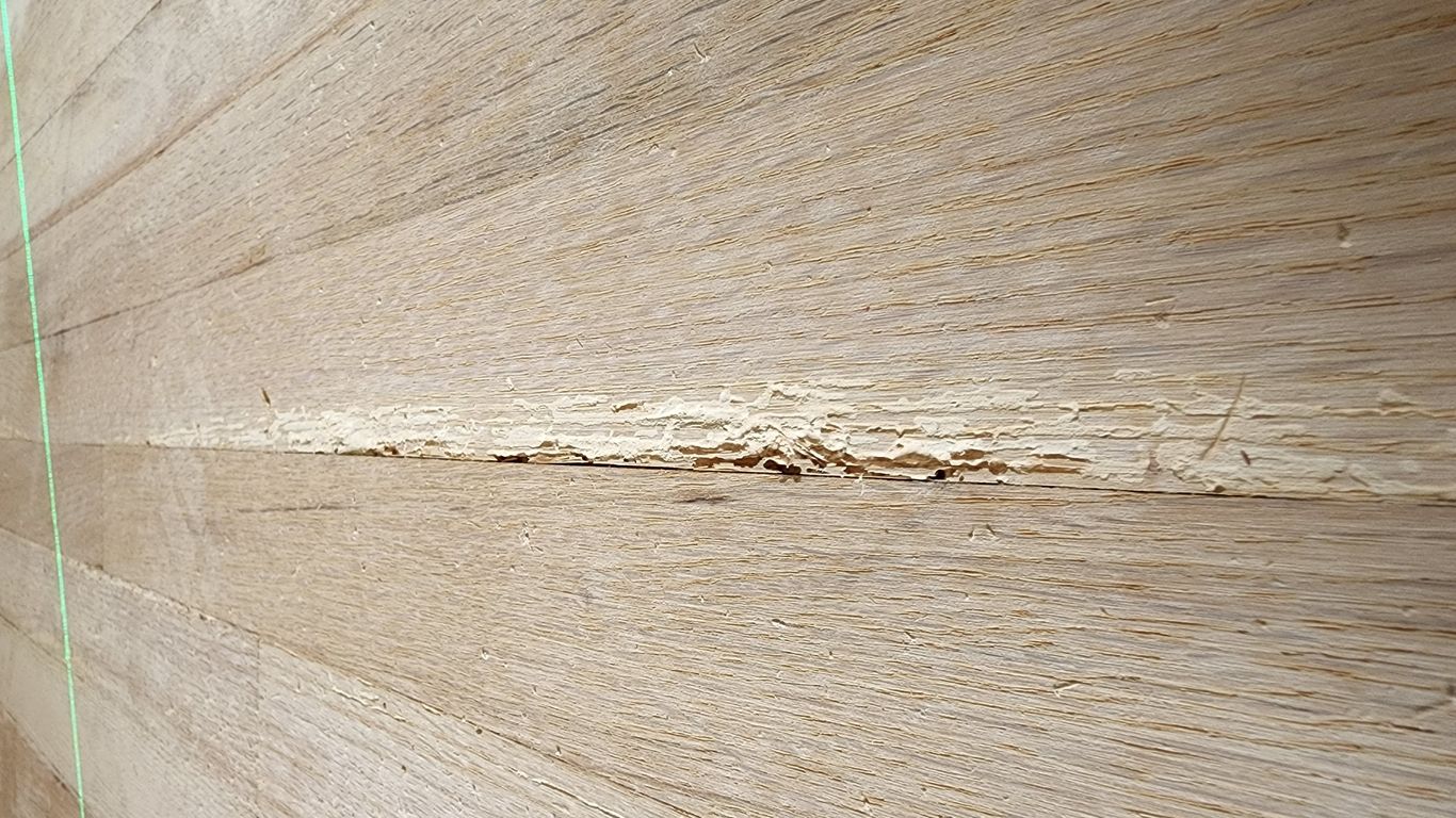 Wooden floor with a noticeable crack running through it.