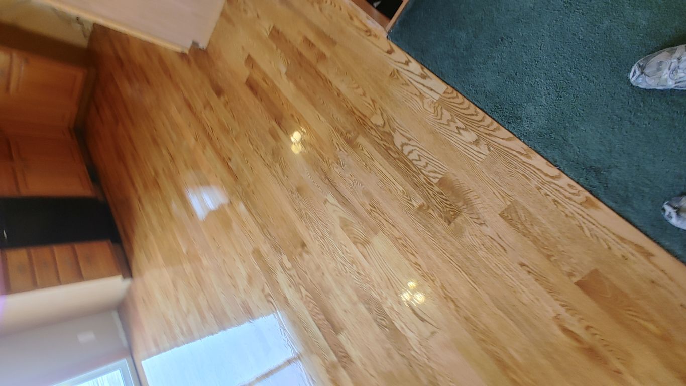 Bright, polished hardwood floor in a spacious kitchen area.