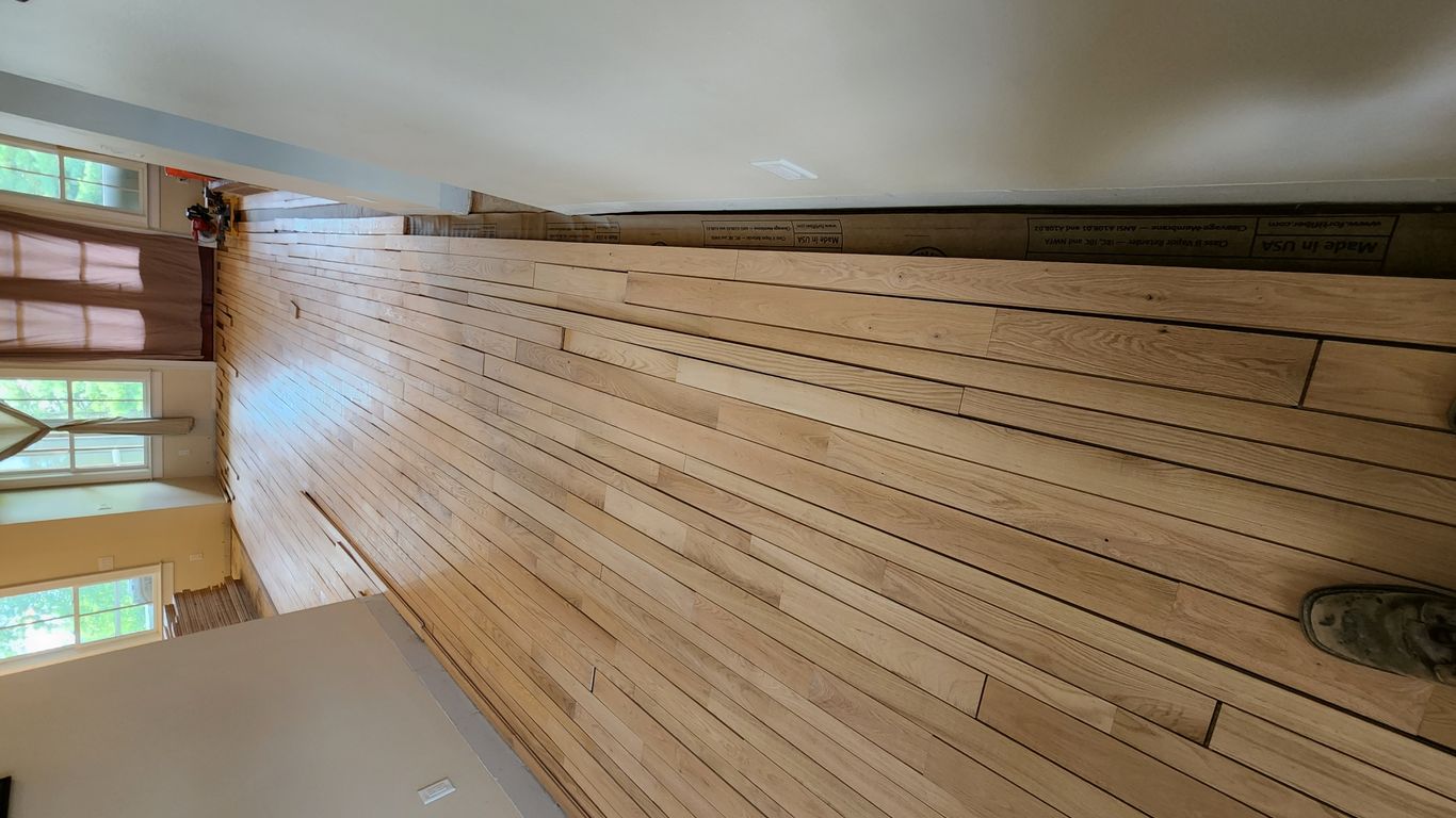 Wooden floor installation in a light-filled interior space.
