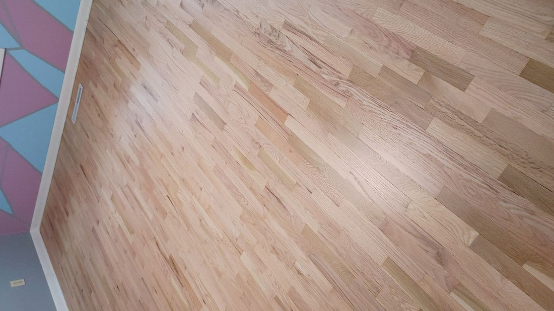 The image shows a polished wooden floor in a room.
