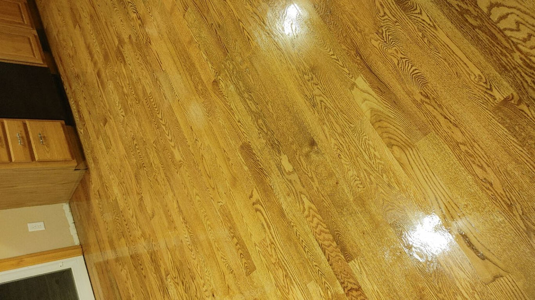  polished wooden floor reflecting light in a kitchen setting.