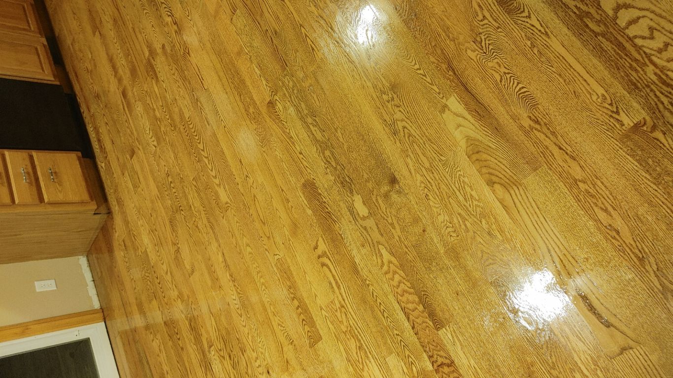  polished wooden floor reflecting light in a kitchen setting.