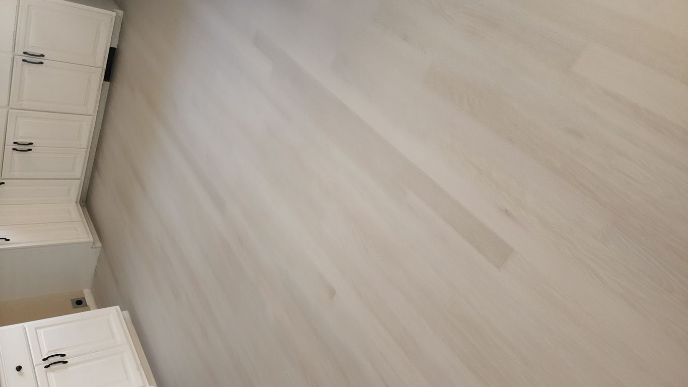 Light-colored wooden floor in a kitchen setting.