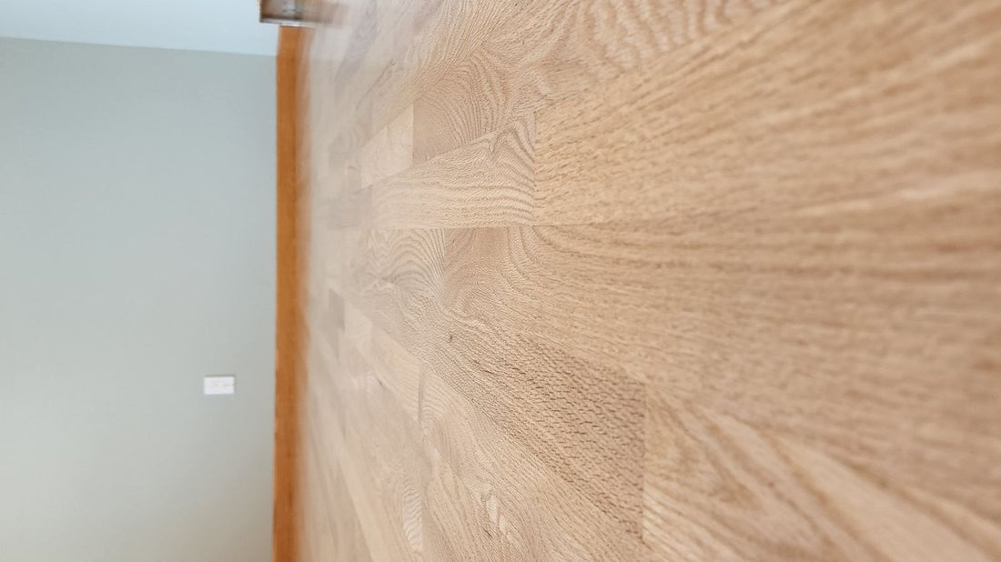 A wooden floor in a room with light walls.